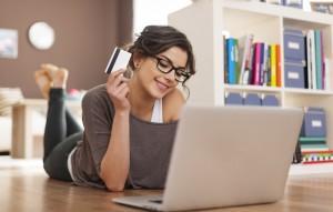 Woman shops online with credit card in hand