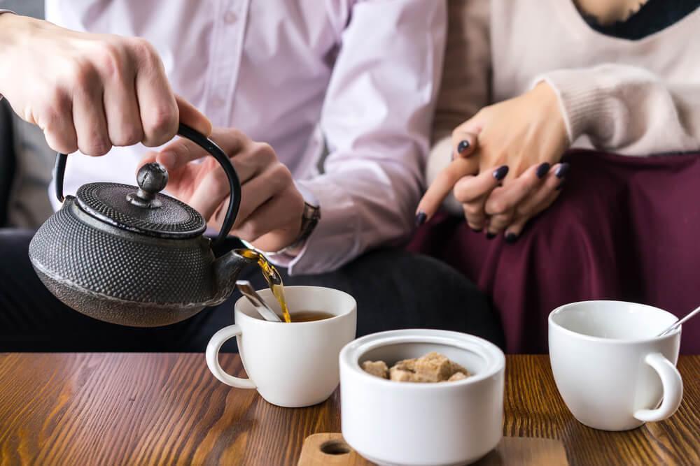 Couple pouring tea into cups