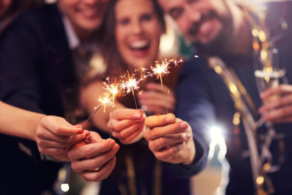 Friends at party holding sparklers