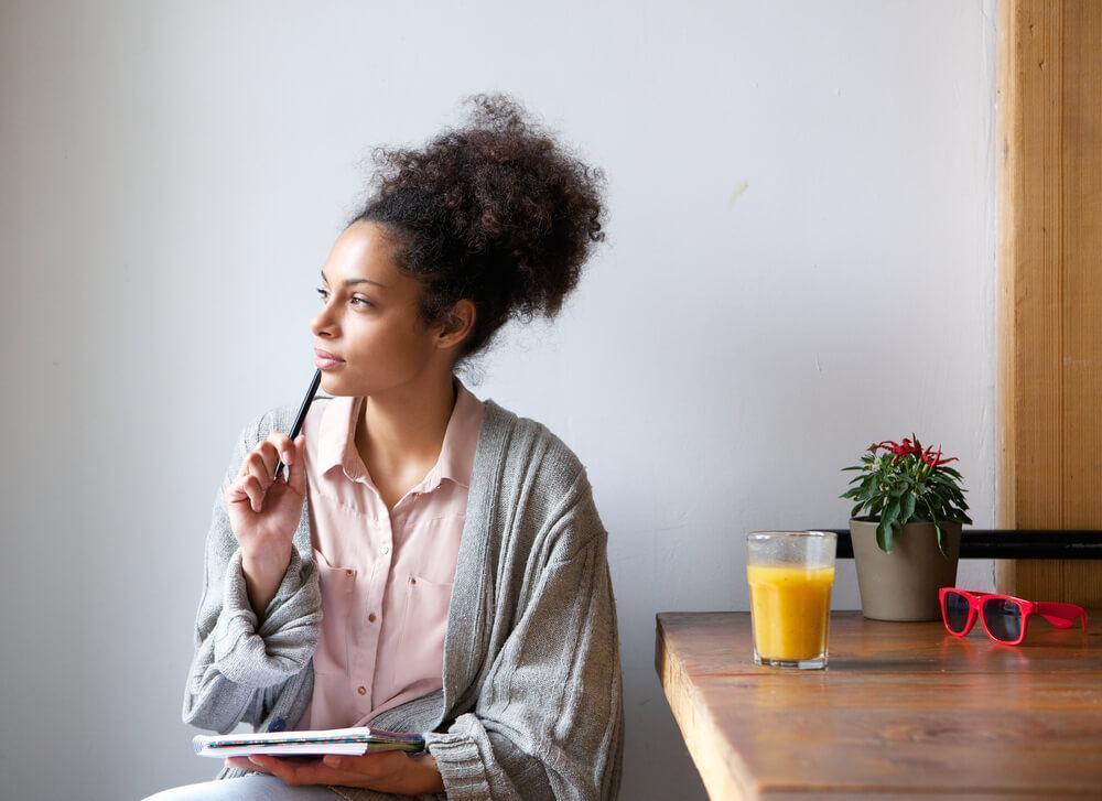 Woman thinking with pen to her lips