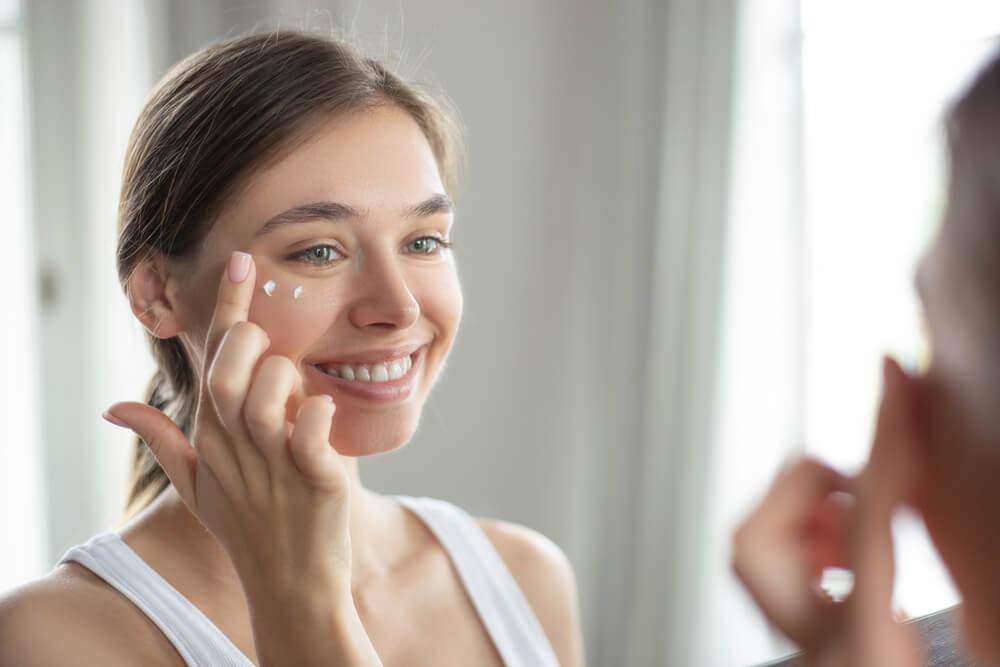 Woman applying skin cream to her face