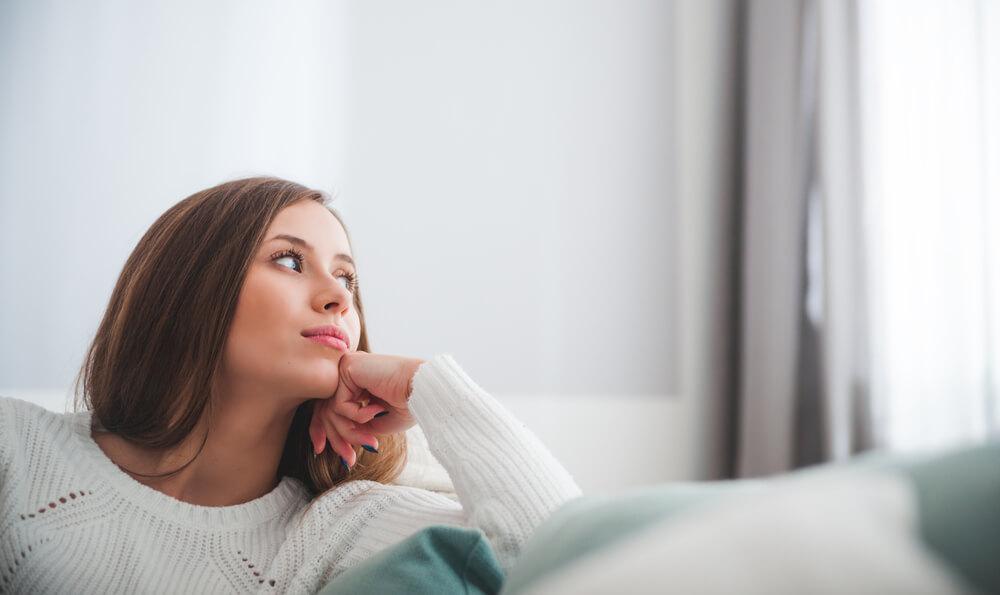 Woman on sofa thinking