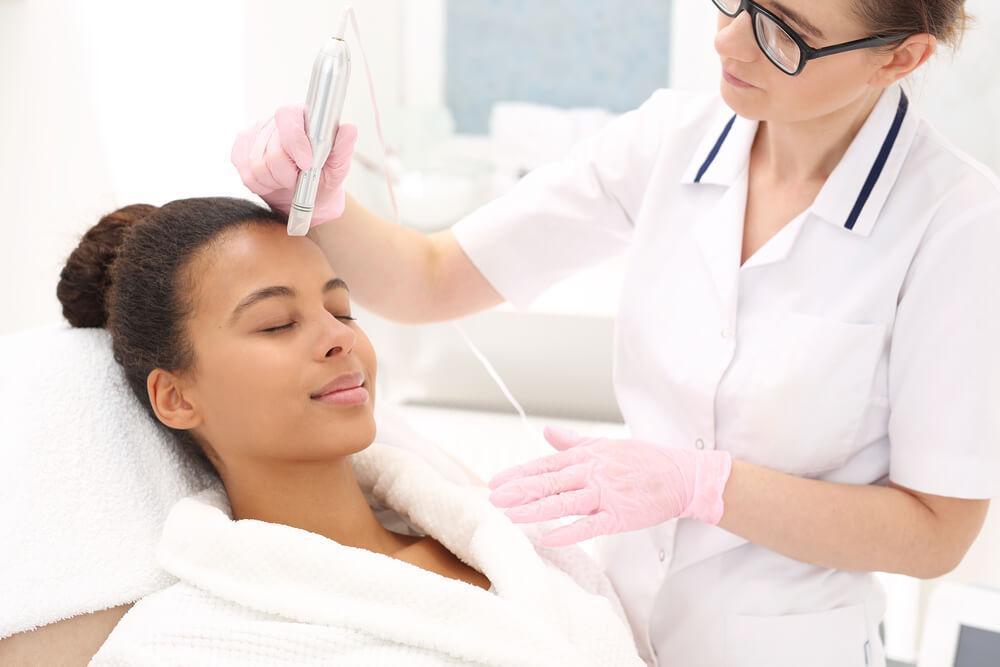 Woman having microneedling done to face