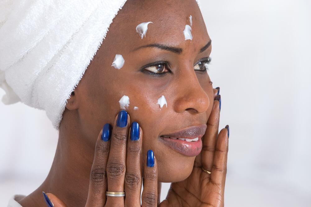 Woman with spot treatment cream on face