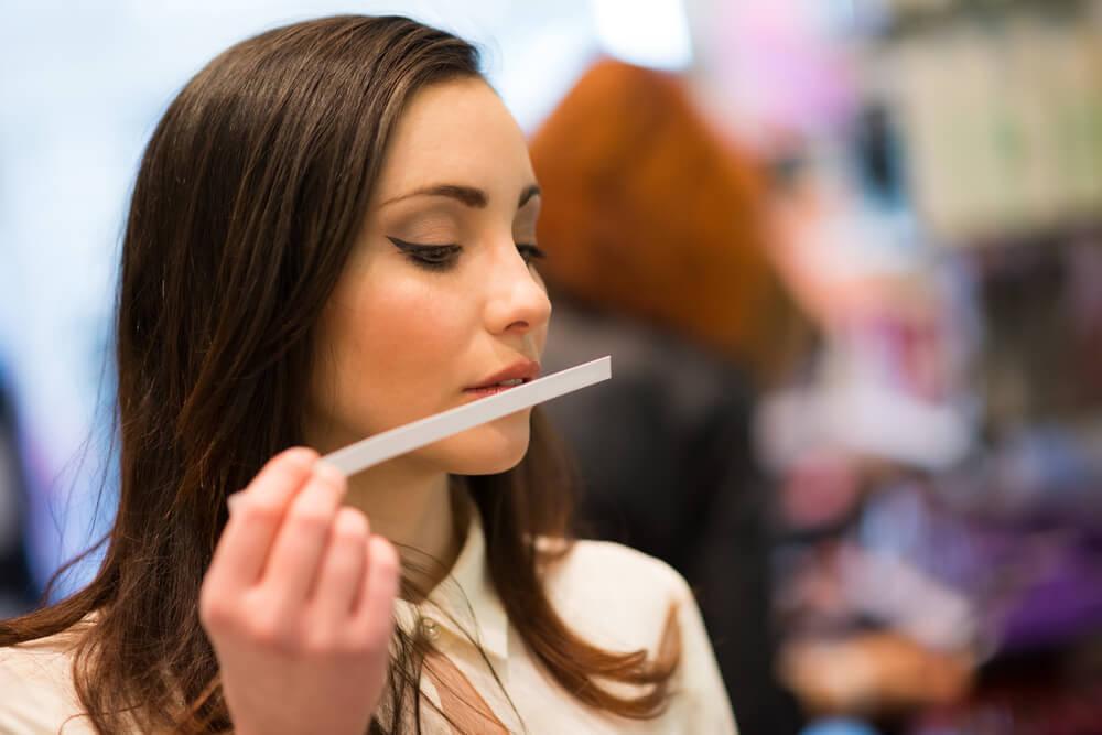 Woman sniffing perfume tester strip