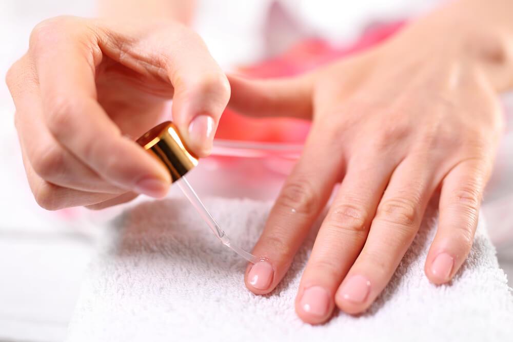 Woman using cuticle oil