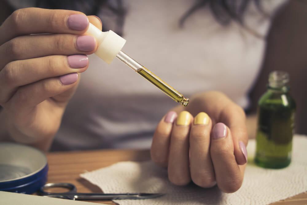 Woman using cuticle oil on nails