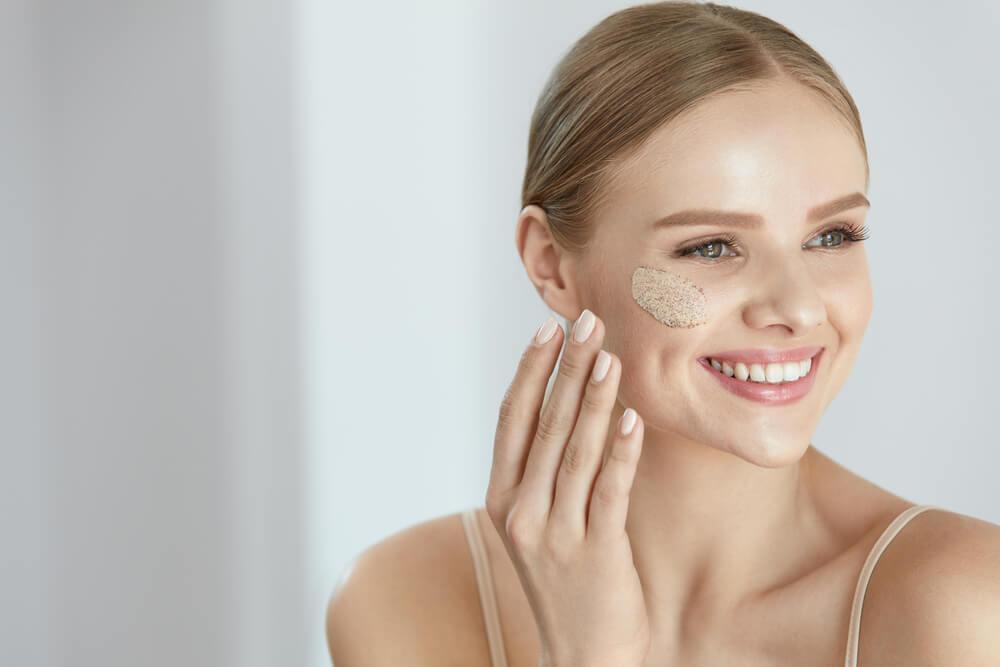 Woman using scrub on face