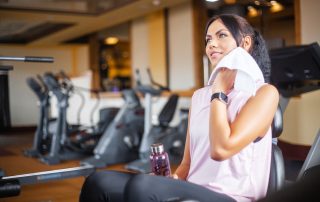 Woman in gym thinking about her post-workout skincare routine